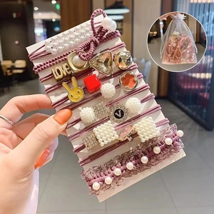 Purple elastic hair ties set with pearls, rabbit charms and lace in a mesh gift bag