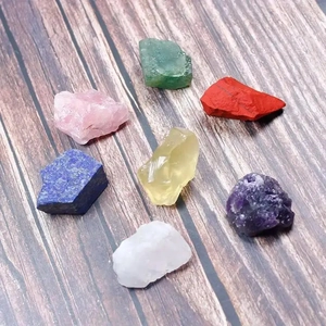 Collection of seven colorful raw natural healing crystals on dark wood texture background