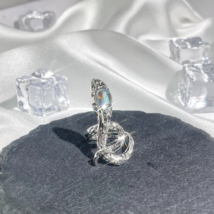Detail of silver snake ring with a colorful iridescent gemstone on a black stone base