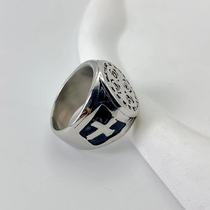 Gros plan d'une bague d'exorciste rétro en acier inoxydable avec gravure religieuse
