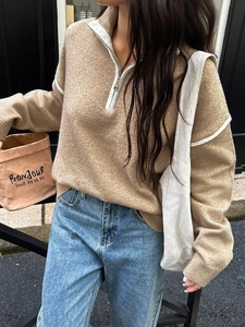 Detail of camel half-zip knit sweater with white stripe accents and casual loose fit