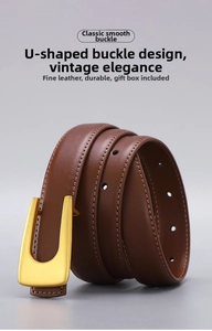 Detail of brown leather belt showing matte gold U-shaped buckle and fine stitching