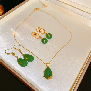 Detail view of gold-plated teardrop glaze stone earrings and necklace in a jewelry box