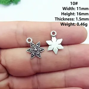 Macro view of a vintage silver snowflake alloy charm showing detailed product dimensions