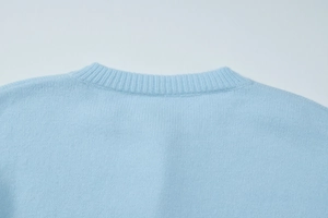 Close-up of the ribbed neckline and fine knit texture on light blue cardigan top