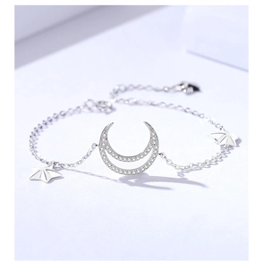 Detail of s925 silver bracelet featuring cubic zirconia crescent moon and star charms