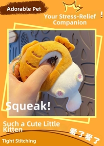 Detail showing hand squeezing yellow and white plush cat charm with golden metal ring