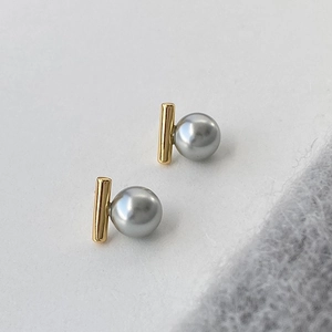 Detailansicht goldener geometrischer Ohrstecker mit grauen Perlen im Vintage-Stil