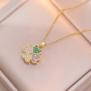 Detailed view of a rotating clover necklace with colorful zircons in a pink jewelry box