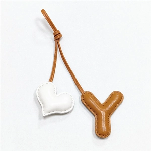 Handmade brown leather Y-letter and white heart bag charm with premium stitching details