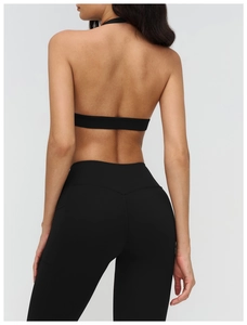 Dettaglio del reggiseno yoga incrociato e leggings che mostrano il tessuto sportivo nero