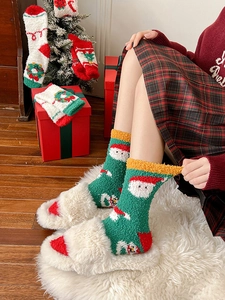 Close-up of green Christmas socks with Santa and snowman patterns in a festive setting