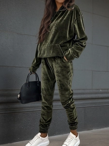 Outdoor shot of dark green velvet tracksuit set with a hoodie and joggers in side view