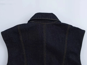 Vue détaillée du col arrière d'un gilet en jean bleu foncé avec surpiqûres