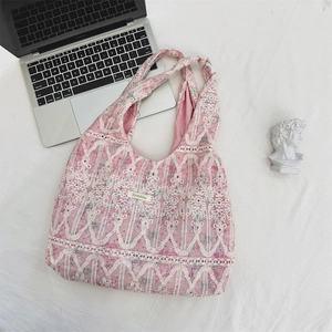 Detail of pink canvas shoulder bag featuring white lace embroidery and Sozakka label