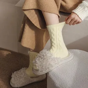 Thick warm winter cable knit socks in yellow paired with cozy white fleece slippers
