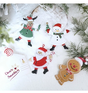 Detail of painted metal Christmas ornaments with Santa, Snowman and Deer on faux snow