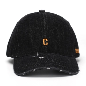 Detail of distressed black denim baseball cap with orange C and 1997 embroidery