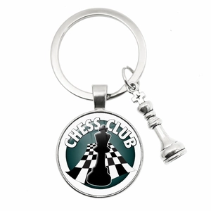 Polished silver chess club keychain featuring a glass cabochon and metal piece charms