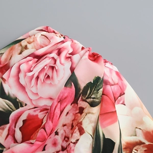 Macro shot of red floral rose print on soft chiffon fabric with elegant leaf patterns