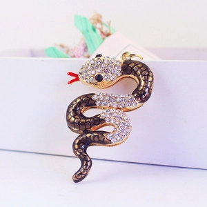 Golden snake keychain with crystal rhinestones and red tongue detail on white background
