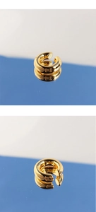 Detailed close-up of chunky minimalist C-shaped gold ear cuff with polished finish