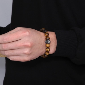 Tiger eye beaded bracelet for men with silver skull charm on male model wrist