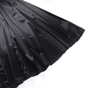 Gros plan de l'ourlet en satin noir montrant le drapé de qualité et les plis élégants
