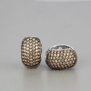 Macro shot of silver ear studs with pave-set champagne zircons in an oval design