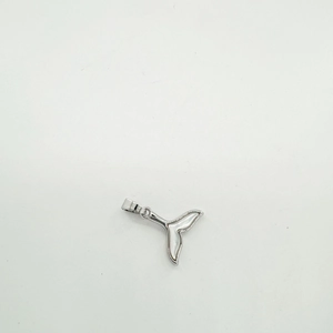 Close-up of a silver whale tail pendant with inlaid white shell on a white background