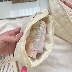 Quilted pouch interior showing storage space for cosmetics and stationery items
