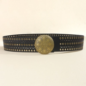 Detail eines breiten Boho-Gürtels aus schwarzem PU mit Bronzeschnalle und Metallösen