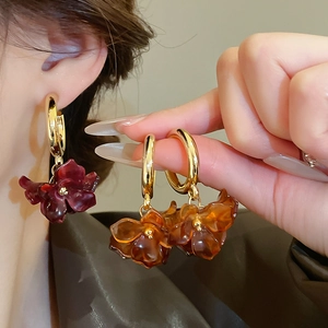 Macro detail of vintage resin flower earrings in amber and gold for elegant styling