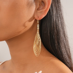 Detail of elegant gold-toned multi-layer hollow mesh earrings worn by a model