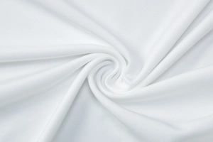 Close-up of premium white knit fabric with elegant pleated texture and soft drape