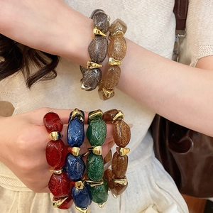 Detailed shot of multi-color glitter acrylic bracelets with golden metal spacers