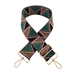 Detail of adjustable bag strap with geometric V-pattern jacquard and gold metal clasps