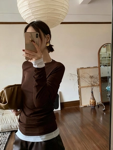 Dark brown long sleeve top with layered white detail in a chic mirror selfie view