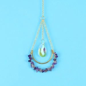 Detail of golden moon suncatcher with purple crystals and iridescent prism pendant