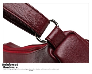 Detail of wine red lychee grain leather with reinforced metal D-ring hardware on handbag