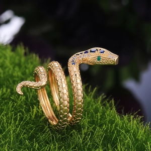 Detalle macro de anillo de serpiente dorado con circonitas dorada con circón azul y escamas grabadas