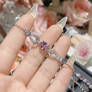 Macro shot of silver bracelet featuring a pink oval gemstone and pavé-set zircons