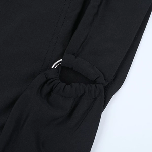 Détail du tissu en maille noire élastique avec anneau métallique argenté sur l'épaule