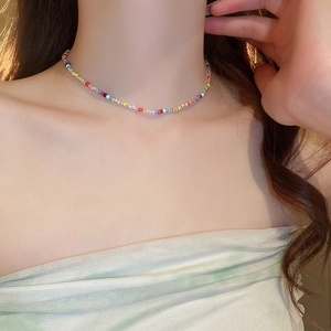 Detail of colorful beaded choker necklace on model featuring vibrant small round beads