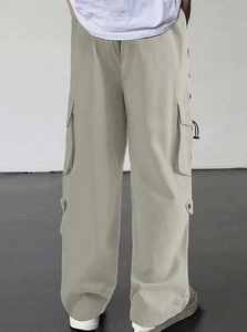 Detail view of light grey parachute cargo pants featuring side pockets and button accents