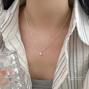 Elegant S925 sterling silver heart pendant necklace worn with a casual striped shirt