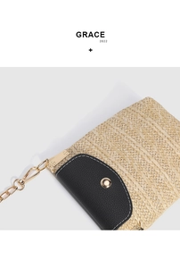 Detail of straw weave texture and black leather flap with gold buckle on a crossbody bag