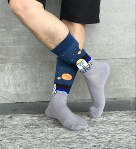 Detail of space-themed crew socks showing rockets and planets on navy blue cotton fabric