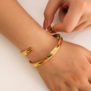 Minimalist 18K gold-plated C-shaped open cuff bracelet for women shown on model wrist