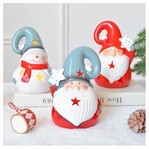 Close-up of ceramic Santa and snowman figurines with star cutouts for festive decor